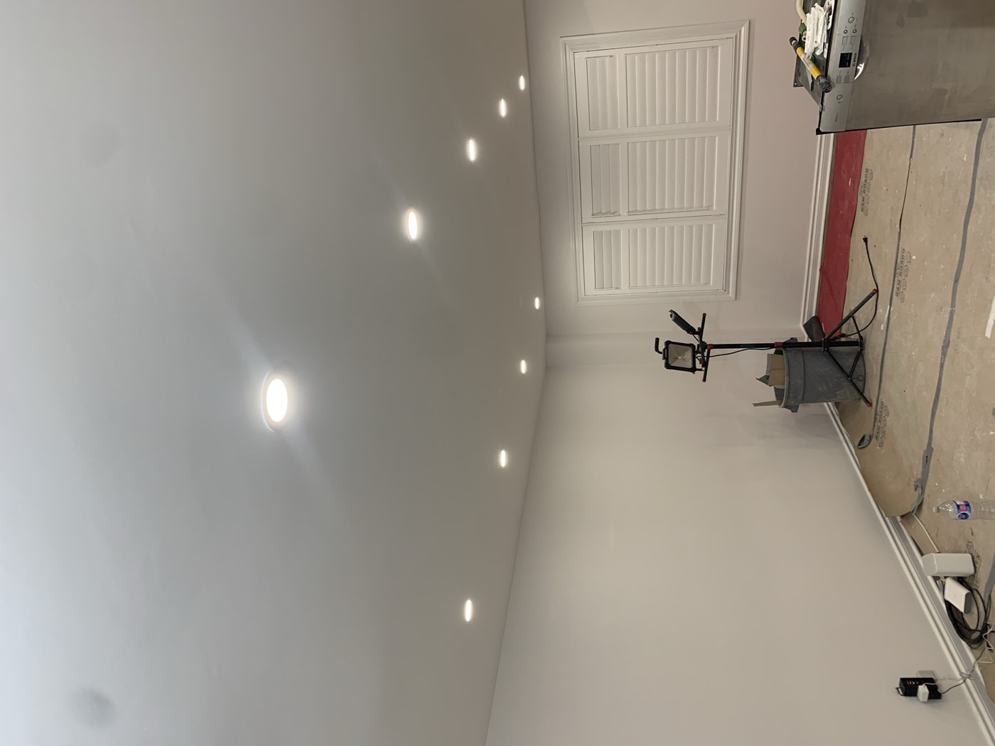 Newly installed recessed pot lights in a renovated basement ceiling